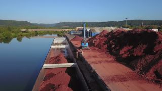 Link zum Video | Frachtschiff, Saarland, Frachtschifffahrt, Saar, Schifffahrt, Merzig, Logistik, Bagger, Deutschland, Verladung, Fluss, Hafen, Luftaufnahme, Industrie