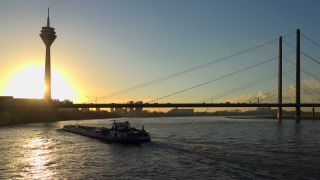 Link to Video | cargo ship, North Rhine-Westphalia, waterway, transport, cargo shipping, sunset, Düsseldorf, logistics, Germany, Rheinknie Bridge, river, Rhine, Rheinturm, thoroughfare