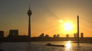 Link to Video | cargo ship, North Rhine-Westphalia, waterway, transport, cargo shipping, sunset, Düsseldorf, logistics, Germany, Rheinknie Bridge, river, Rhine, Rheinturm, thoroughfare