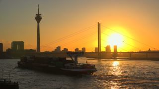 Link to Video | cargo ship, North Rhine-Westphalia, waterway, transport, cargo shipping, sunset, Düsseldorf, logistics, Germany, Rheinknie Bridge, river, Rhine, Rheinturm, thoroughfare