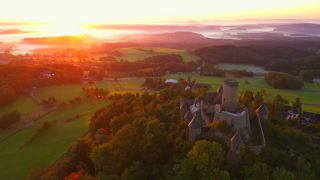 Link to Video | landscape, bird's-eye view, tourist destination, time of the day, landscape element, castle ruin, Nürburg Castle, terrain, sunrise, landform, Eifel (Rhineland-Palatinate), Europe, aerial shot, Adenau, tourist attraction, Nürburg, human-made geographic feature, architectural structure, Ahrweiler, point of interest
