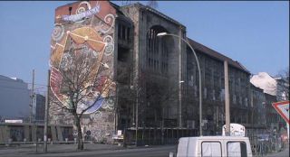 Link to Photo | March, spring, big city, graffiti, Germany, façade, Mitte, screenshot, 1998, color, 35 mm film, point-of-view shot, historic building, 2K resolution, capital city, Kunsthaus Tacheles, photographic film, Berlin, Oranienburger Straße, Auguststraße, Berlin Babylon, driving