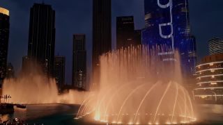Link to Video | downtown, skyscraper, dance, JMW, tourist destination, architecture, establishing shot, show, choreography, light installation, colorful, color, spectacle, 4K resolution, The Dubai Fountain, water feature, liquid water, building, dancing, fountain, Moderne architecture, 2023, tourist attraction, night, Dubai, United Arab Emirates