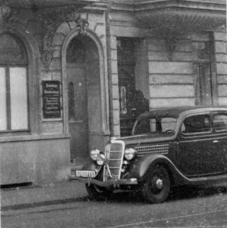 Link to Photo | health insurance company, entrance, passenger car, signage, 40s, motor car, Ford Model A, Germany, Essen, Ford, Werden, parking, 1940s, building, antique car, classic car, 20th century, 73, black and white