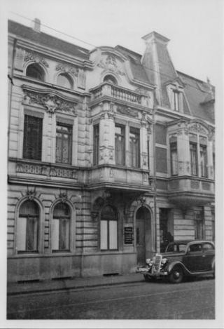 Link to Photo | health insurance company, entrance, passenger car, signage, 40s, motor car, Ford Model A, Germany, Essen, Ford, Werden, parking, 1940s, building, antique car, classic car, 20th century, 73, black and white